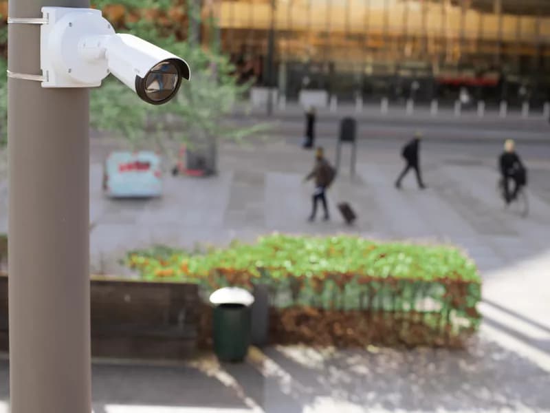 P1468 mounted on a pole in a city square. People are walking in the background. from Axis Communications